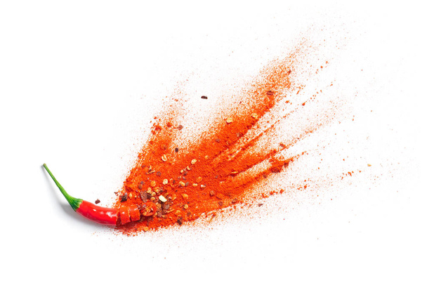 Chili poeder en vlokken barsten uit van rode chili peper - Foto, afbeelding