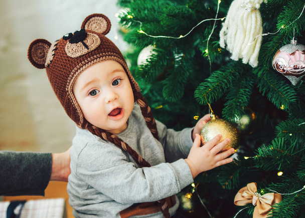 One-year-old child impressed by his first time decorating the Christmas tree. his first New Year - Фото, зображення