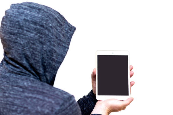 Man in gray sweatshirt hood holds tablet pc computer with blank screen for copy space isolated on white studio background. - Photo, Image
