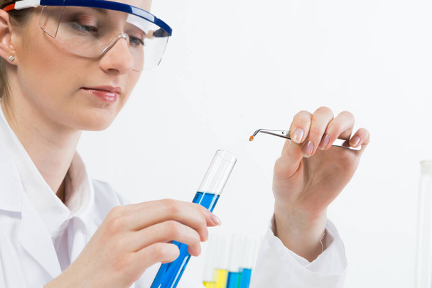 Scientist puts sample into test tube with liquid - Фото, зображення