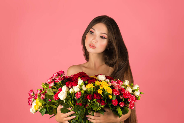 young beautiful woman with flowers isolated on pink background - Фото, изображение