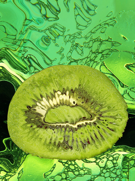 Slice of ripe kiwi taken closeup on green abstract background. - Valokuva, kuva