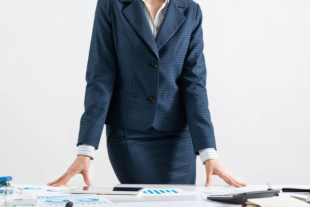 Businesswoman in suit standing near office desk - 写真・画像