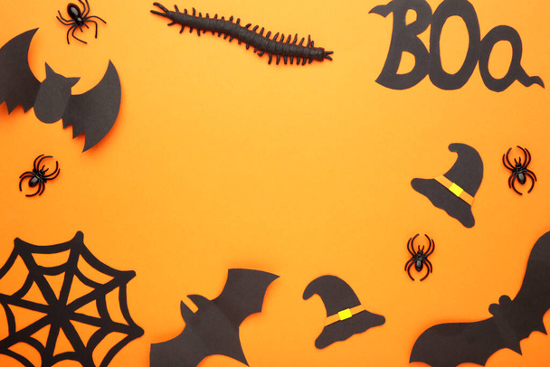 Halloween composition with spiders and bats on orange background. Top view - Photo, Image