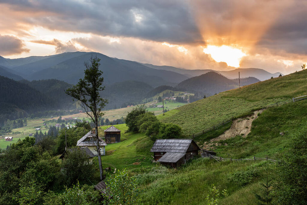 Pôr do sol em uma aldeia de montanha nos Cárpatos ucranianos. Verdes encostas de montanha e raios laranja do pôr-do-sol., Ucrânia, Europa. - Foto, Imagem