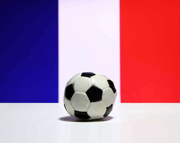 Kis labdarúgás a fehér padlón és a Tri Color vagy kék fehér és piros színű francia nemzeti zászló háttér. A sport fogalma. - Fotó, kép