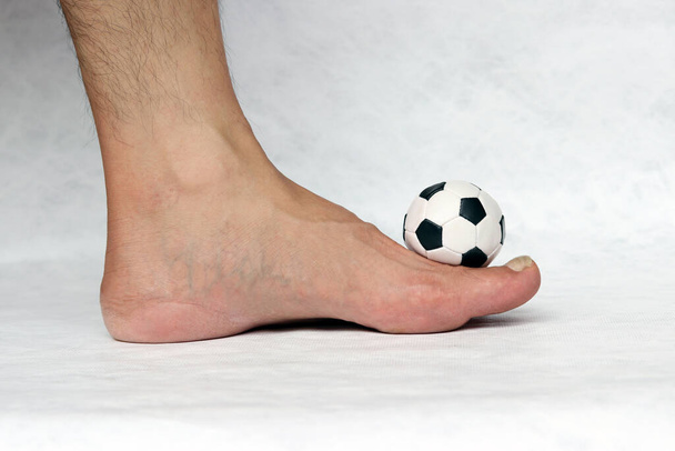 Мини мяч футбола на ноге с белым фоном. Концепция спорта. - Фото, изображение