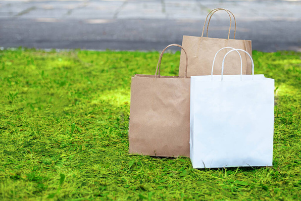 Papierowe torby na trawie. Odmów plastikowym torbom. Koncepcja dostawy towarów i produktów. - Zdjęcie, obraz