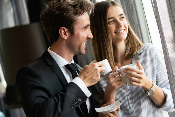 Young businesswoman with male colleague discussing. Businessman and businesswomen drinking coffee - Φωτογραφία, εικόνα