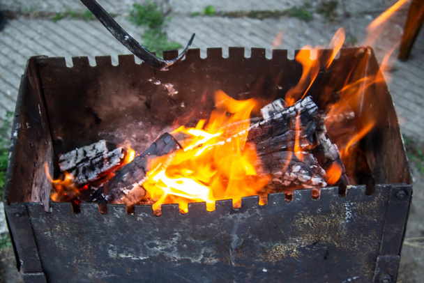Barbacoa parrilla preparación mangal con fuego roaming fuera del edificio. Quema una leña - Foto, imagen