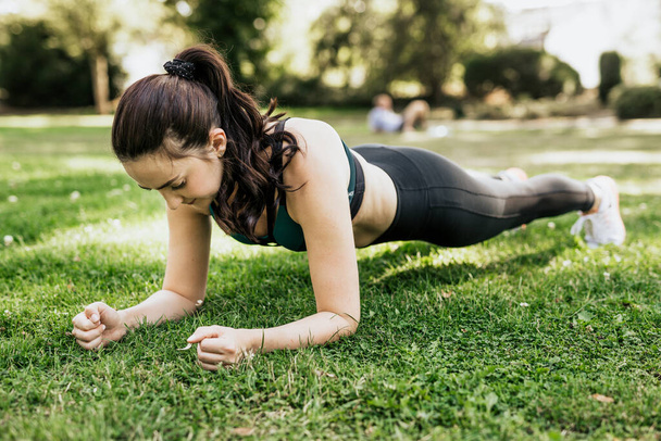Deportiva mujer hacer ejercicio sobre hierba verde - Foto, imagen
