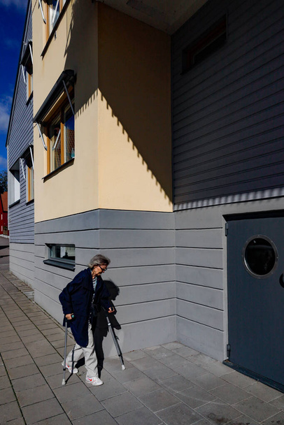 Nykoping, Sweden  A senior pedestrian  in the  neighbourhood of Brandholmen. - Fotoğraf, Görsel