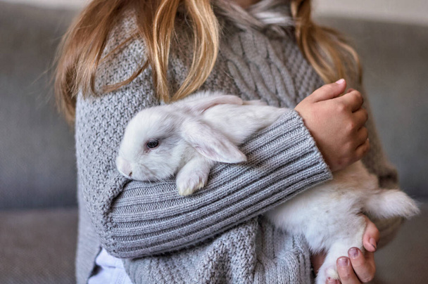 chica rubia con un conejo blanco en sus brazos - Foto, imagen