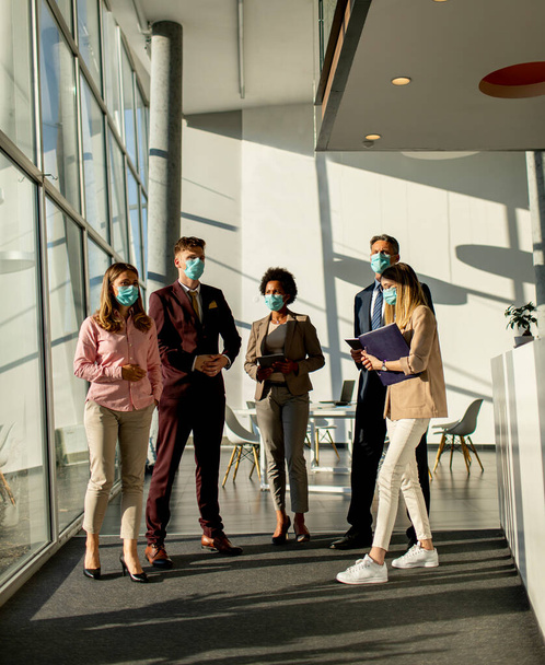 Група ділових людей, які зустрічаються і працюють в офісі і носять маску для захисту від зараження вірусом корони
 - Фото, зображення