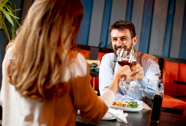 Schönes Liebespaar verbringt Zeit miteinander und stößt im modernen Restaurant auf die Gläser an - Foto, Bild