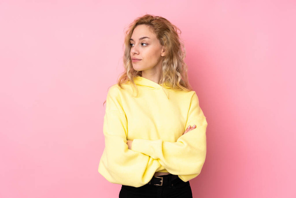 Young blonde woman wearing a sweatshirt isolated on pink background portrait - Photo, Image