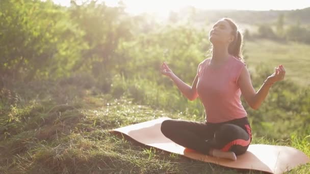 Das Mädchen praktiziert Yoga an einem sonnigen Tag - Filmmaterial, Video