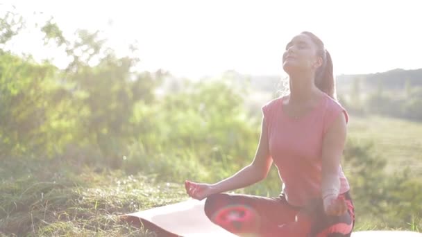 Mujer entrenando yoga y meditación sobre la roca en la montaña - Imágenes, Vídeo