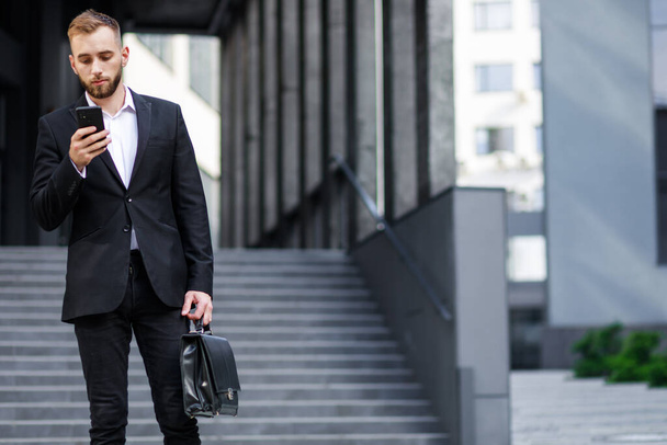 młody mężczyzna w formalnym garniturze za pomocą smartfona  - Zdjęcie, obraz