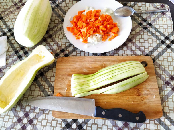 Trochę posiekanych warzyw na stole do krojenia, cukinia, marchewka, cebula - Zdjęcie, obraz