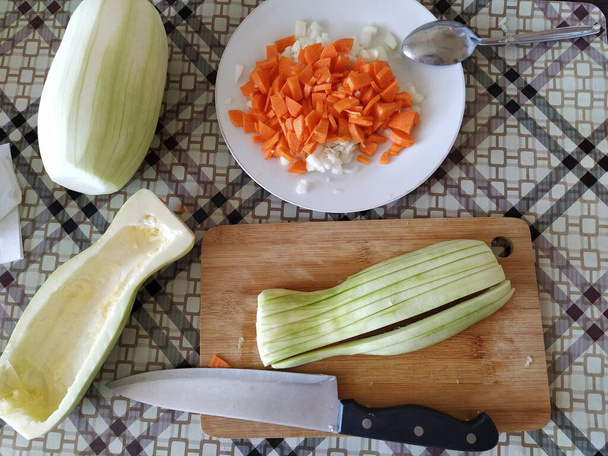 Pilkottuja vihanneksia leikkauspöydällä, kesäkurpitsaa, porkkanaa, sipulia - Valokuva, kuva