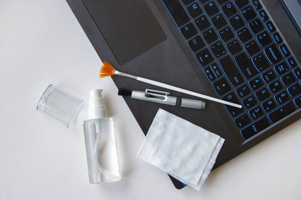 Keyboard, napkin, antiseptic and brushes on a white background. Cleaning concept. Office cleaning. - Foto, imagen