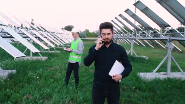 У солнечных инженеров, с ноутбуком на солнечной ферме, в специальном унифоре. - Кадры, видео