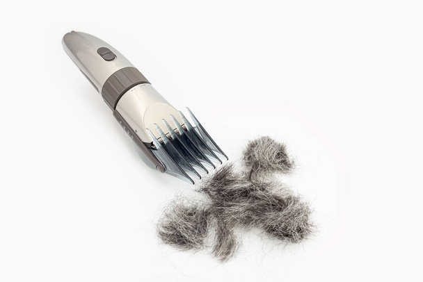 Hair clipper and cut hair isolated on white background. Hair cutting tool - Photo, Image