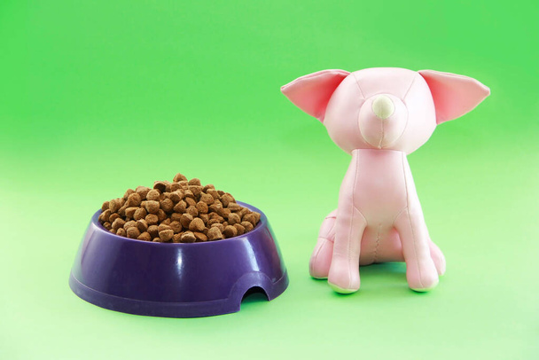 droog hondenvoer en roze hondenspeelgoed - Foto, afbeelding