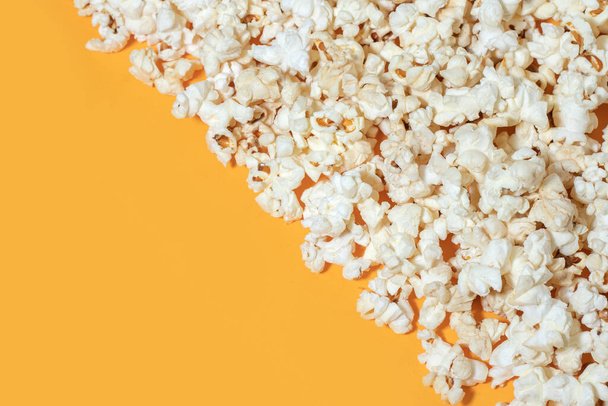 Smaczny solony popcorn na żółtym tle - Zdjęcie, obraz