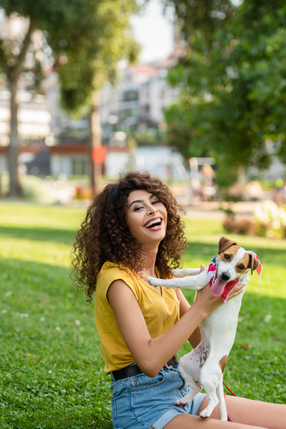 Selective focus of excited woman with jack russell terrier dog looking at camera - Photo, Image