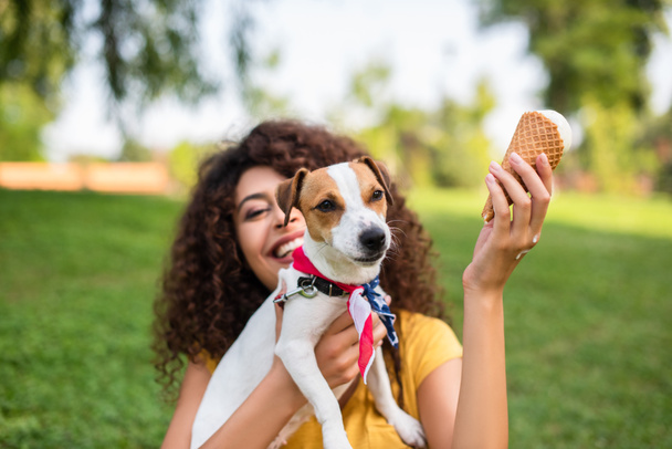 Selective focus of young woman holding ice cream and jack russell terrier dog - Foto, Imagen