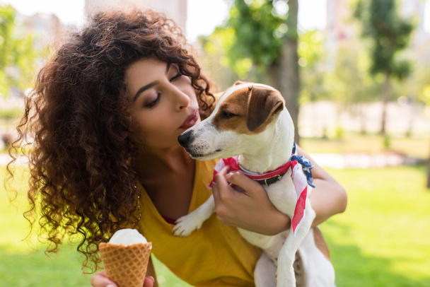 Selective focus of young woman looking at dog and making blowing kiss - Photo, Image