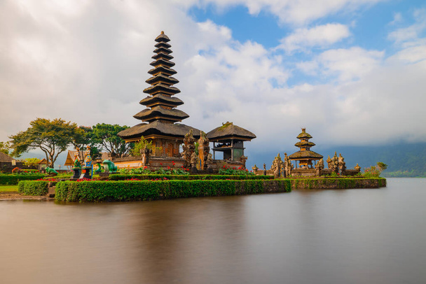 Tempio di Pura Ulun Danu Bratan nell'isola di Bali. Bellissimo tempio balinese. Punto di riferimento balinese. Cielo nuvoloso. Riflessione sull'acqua. Velocità di scatto lenta. Lago di Bratan, Bali, Indonesia - Foto, immagini