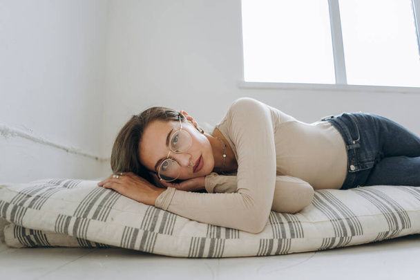 Closeup of young woman lying on mattress - Фото, изображение