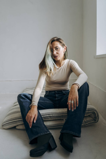 stylish girl sitting on mattress in room - Valokuva, kuva