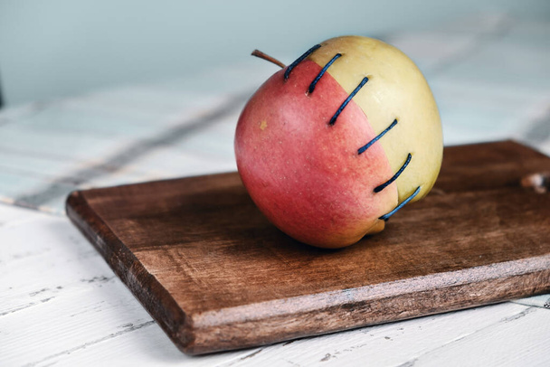 Δύο διαφορετικά μισά μήλου συνδεδεμένα με νήμα - Φωτογραφία, εικόνα
