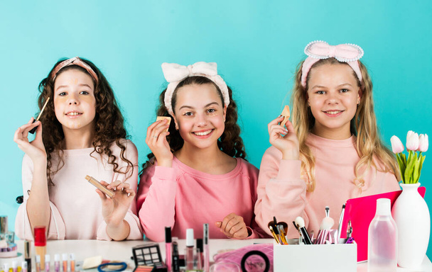 Control oil. Prevent acne. Kids makeup. Skin care concept. Cosmetics for children. Beauty and fashion. Happy girls doing makeup together. Sisterhood happiness. Cosmetics shop. Apply lipstick - 写真・画像