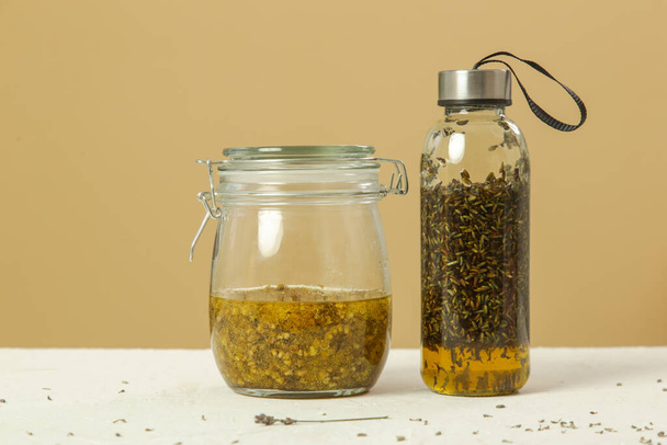 Herbal infused oils with yellow immortelle and lavandula flowers. Process of maceration. - Fotó, kép
