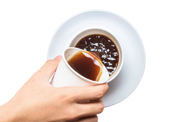 Hand gieten van de koffie van piepschuim beker om de mok beker geïsoleerd over witte achtergrond - Foto, afbeelding