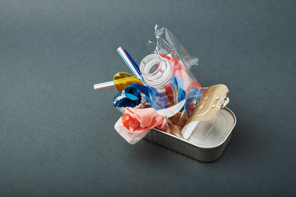 Lata aberta. Resíduos de plástico em vez de peixe dentro. Conceito de poluição oceânica - Foto, Imagem