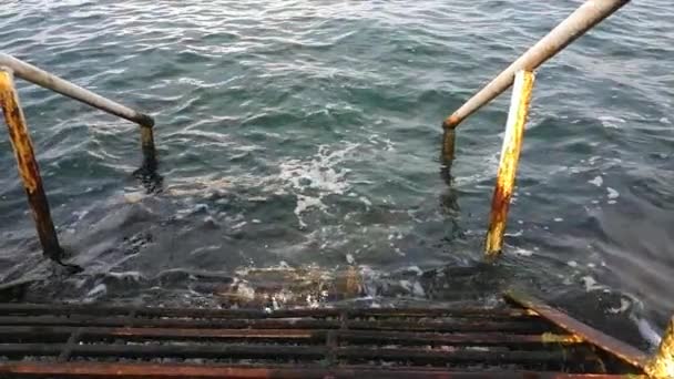 escadas de ferro enferrujado velho com corrimão descendo em água azul - Filmagem, Vídeo