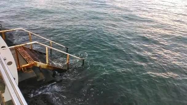 vieil escalier en fer rouillé avec rampe descendant en eau bleue - Séquence, vidéo