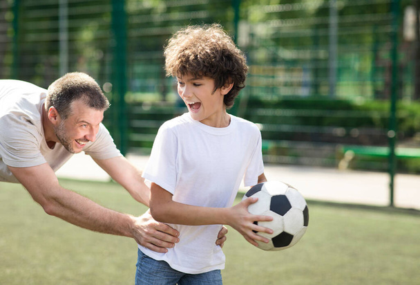 楽しいお父さんは息子にサッカーのやり方を教えて - 写真・画像