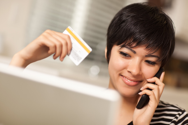 telefonu ve dizüstü kullanarak kredi kartı tutan çok ırklı kadın - Fotoğraf, Görsel