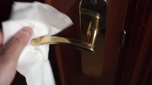 Cleaning and disinfecting the door handle from Germs, bacteria, virus. Hand holding a disposable white cleaning cloth. Protection against coronavirus or Covid-19 - Footage, Video