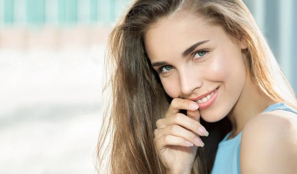 Beauty smiling happy model with natural make up and long eyelashes smiles outdoor. Copyspace. Young pretty student woman in the openspace.  - Foto, Imagem