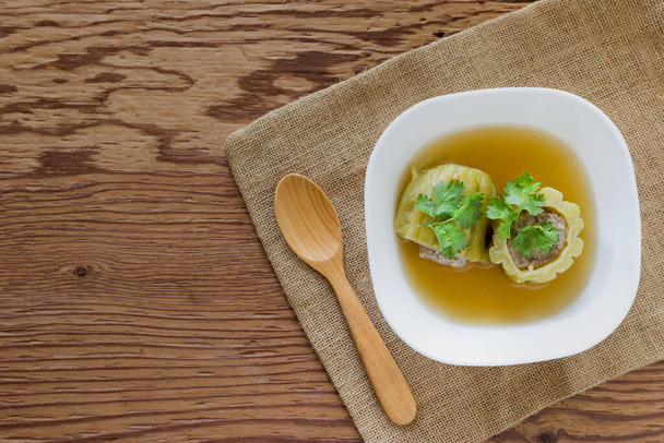 Γεμιστές πικρή κολοκύθα σούπα με καρυκευμένο κιμά χοιρινό σε φόντο ξύλου - Φωτογραφία, εικόνα