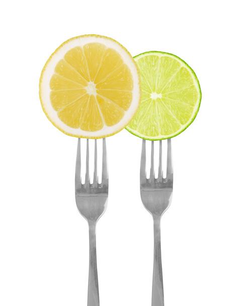 in Scheiben geschnittene Limette und Zitrone von Gabeln - Foto, Bild