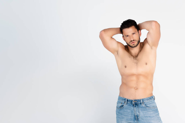 shirtless man in jeans standing and looking at camera isolated on white  - Foto, Imagen